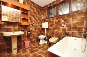 a bathroom with a sink and a toilet and a tub at Apartments Marin in Novalja