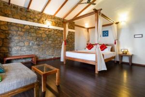 a bedroom with a bed and a stone wall at Neelakurunji Plantation Munnar in Chinnakanal