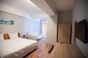 1 dormitorio con cama y sofá en Heights Accommodation en Bucarest