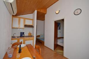 a kitchen and dining room with a table and a clock at Apartments Nada in Vodice