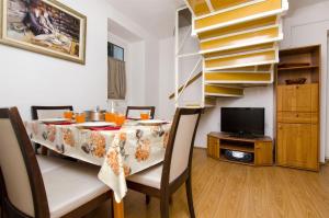 a dining room with a table and a spiral staircase at Apartment Mandic in Omiš