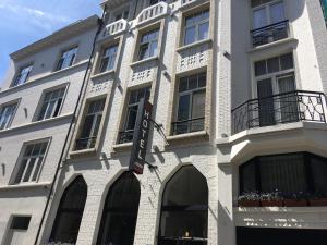 een wit gebouw met een bord aan de zijkant bij Hotel Louisa in Oostende