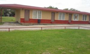 a yellow and red house with a grass field at Relax Inn Ranger in Ranger