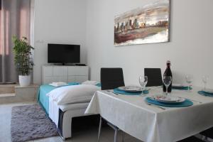 a dining room with two tables and a tv at Apartment Emma in Kaštela
