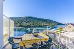 a table and chairs on a balcony with a view of the water at Apartments Nada in Rogoznica