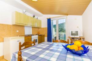 a kitchen with a table with a bowl of fruit on it at Apartments Nada in Rogoznica