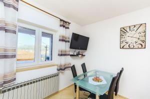een eetkamer met een tafel en een raam bij Apartment Marijana in Trogir
