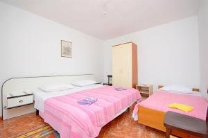 een slaapkamer met 2 bedden en roze lakens bij House Slavka in Gdinj