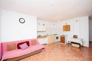 a living room with a pink couch and a kitchen at House Slavka in Gdinj +10 photos