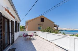 a patio with a table and chairs on a balcony at Apartment RUZA in Lopar
