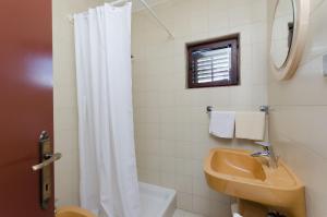 a bathroom with a white shower curtain and a sink at Apartment RUZA in Lopar +24 photos