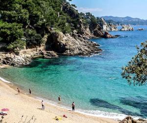 a group of people on a beach near the water at Apartamento Puerto Blanes in Blanes