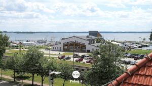 a building with a parking lot next to a body of water at WAM Rooms in Giżycko