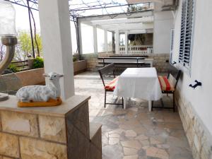 patio con tavolo e statua di pecora di Apartments Anka a Duće