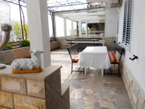 a patio with a table with a sheep statue on it at Apartments Anka 20m from the beach in Duće +35 photos
