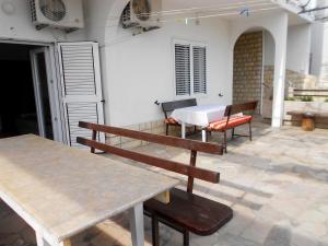 a patio with benches and a table on a patio at Apartments Anka 20m from the beach in Duće