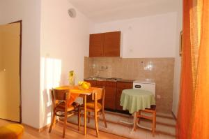 una cucina con tavolo, tavolo e sedie di Apartments Katica a Makarska