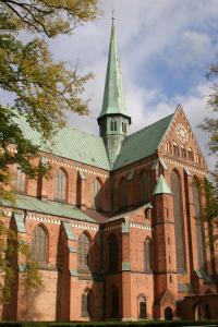 a large brick church with a steeple on top of it at Hotel Doberaner Hof in Bad Doberan