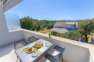 a table and chairs on a balcony with a view at Apartments Villa V in Vir
