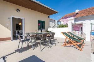 eine Terrasse mit einem Tisch und Stühlen darauf in der Unterkunft House Franka in Vinišće