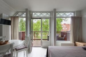 a bedroom with a tub and a view of a balcony at Preilos vasara in Preila