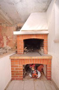 a brick oven in a room with a pizzaigunigunigunigun at Apartment Katija in Postira