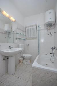 a white bathroom with a sink and a toilet at Apartment Katija in Postira