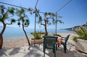 a table and chairs sitting next to a beach at Apartments Jure in Drasnice