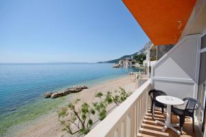 a balcony with a table and chairs and a beach at Apartments Jure in Drasnice