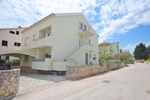 a large white building with a stone wall at Apartment Mare in Srima