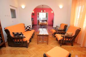 a living room with orange chairs and a table at Apartment Baturina in Trogir
