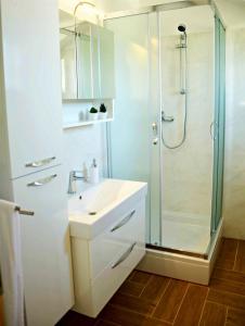 a white bathroom with a shower and a sink at Apartment Luna in Postira