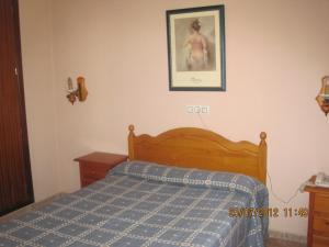 1 dormitorio con 1 cama y una foto en la pared en Hotel Caballo Negro, en Puerto Real