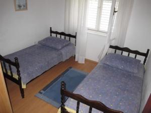 1 Schlafzimmer mit 2 Betten und einem Fenster in der Unterkunft Apartments Ljubica in Vinišće