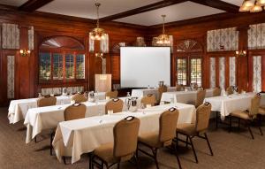 a conference room with tables and chairs and a screen at The Stanley Hotel in Estes Park
