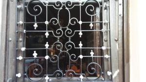 uma porta com um portão de metal com um violino em Posada Santa Eulalia em Villanueva de la Peña