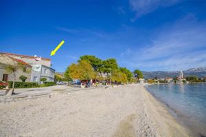 una cometa volando sobre una playa de arena junto al agua en Apartments Mijo, en Kaštela