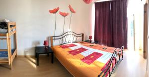 sypialnia z łóżkiem z kwiatami na ścianie w obiekcie Chelsea Riia mnt 28 Apartment w Parnawie