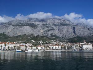 a mountain with a town and boats in the water at Apartments Mise in Makarska