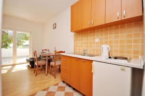 a kitchen with a table and a white refrigerator at Apartments Blazenka in Trogir