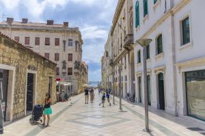 un grupo de personas caminando por una calle de la ciudad en Apartment and Room Old town, en Split