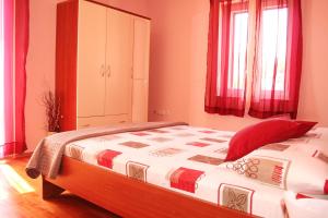 a bedroom with a large bed with red pillows at Apartment Anton in Slatine