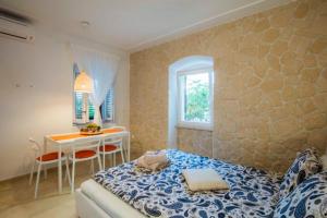 a bedroom with a bed and a table in it at Season4All Apartments in Mali Lošinj