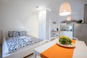 a bedroom with a bed and a table with a bowl of flowers at Season4All Apartments in Mali Lošinj +23 photos