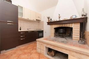 a kitchen with a brick fireplace in a room at House Vela Lozna in Postira +6 photos