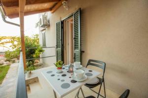 a white table and chairs on a balcony at Season4All Apartments in Mali Lošinj