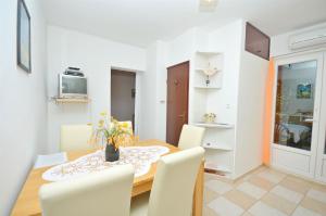 a dining room with a table and white chairs at Apartment Gordan in Murter