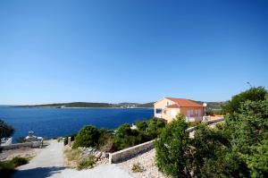 ein Haus am Ufer eines großen Wasserkörpers in der Unterkunft Apartments Marijo in Sevid + 23 Fotos
