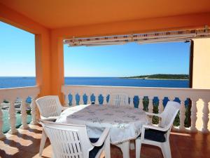 Ein Tisch und Stühle auf einem Balkon mit Meerblick in der Unterkunft Apartments Marijo in Sevid