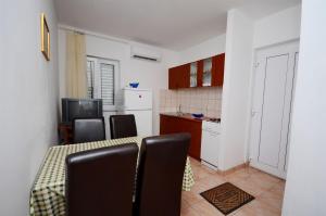 a kitchen with a table and chairs in a room at Apartments Marijo in Sevid